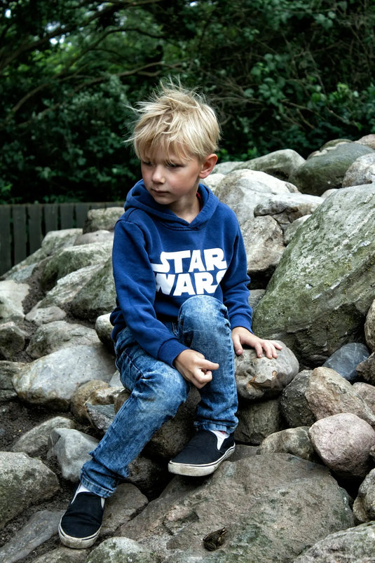 boy seating on rock fragments