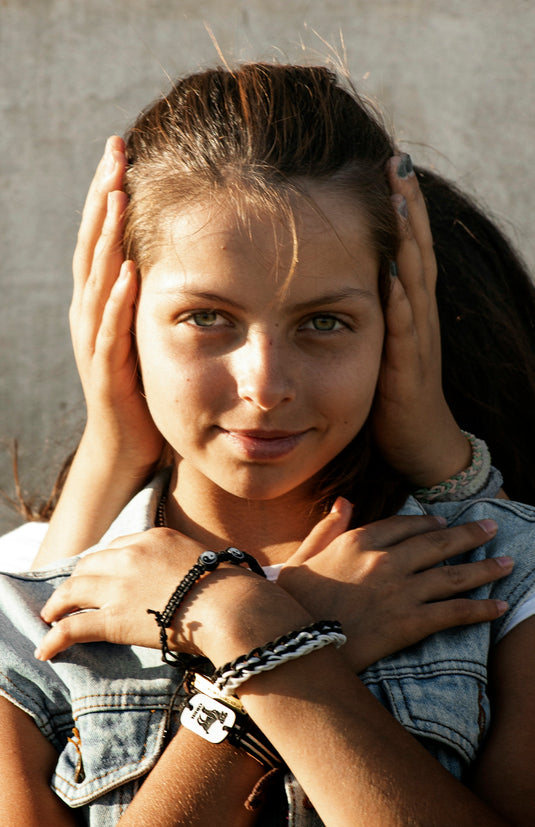 woman in gray shirt holding her hair
