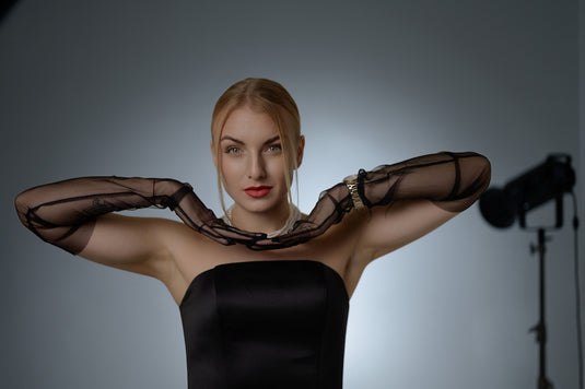 A woman poses elegantly in black attire.