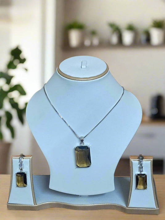 Elegant Pendant Set featuring Smoky Yellow stone and CZ, displayed with matching earrings on a white stand.