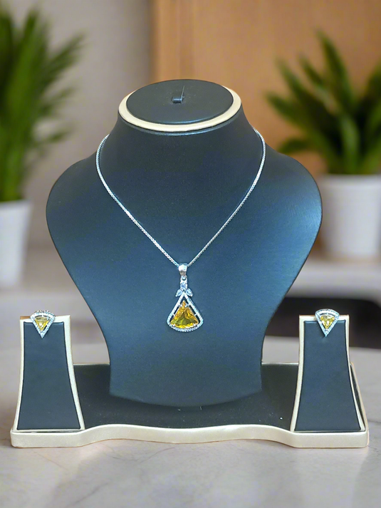 Aqua yellow CZ studded pendant set displayed on a black jewelry stand, featuring a silver-plated chain and matching earrings by Garimas.