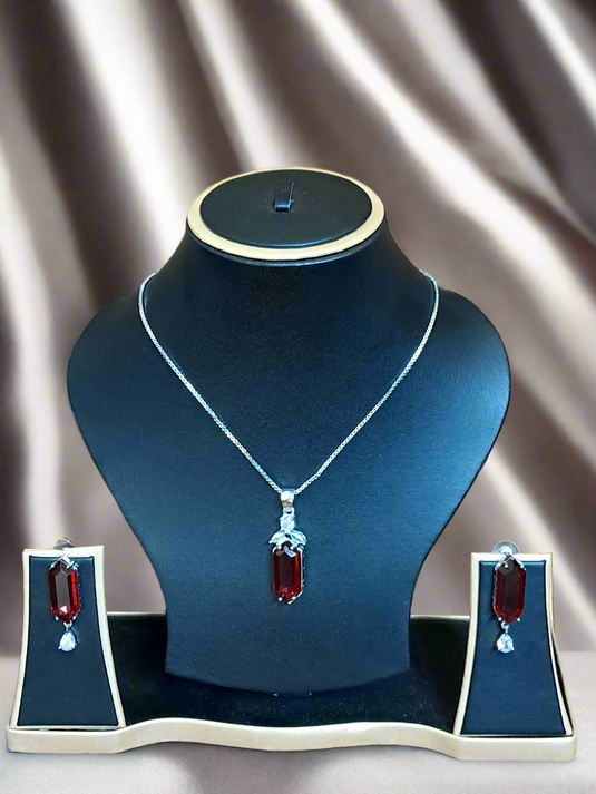 Elegant red ruby and CZ pendant set displayed on a black jewelry stand, featuring a silver-plated chain.