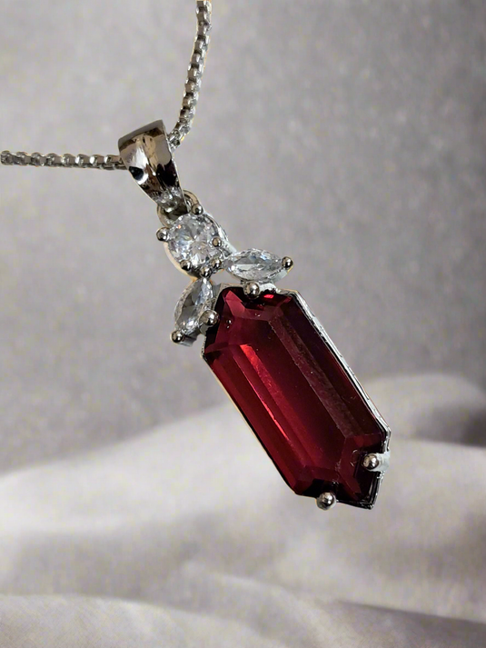 Elegant pendant set with red ruby and CZ stones on a silver-plated chain by Garimas.