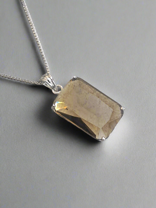 Smoky yellow pendant on a silver chain, part of Garimas elegant jewelry set, perfect for any occasion.
