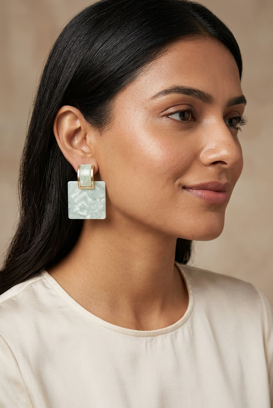 GARIMAS mint green marble-effect square drop earrings worn with gold-tone rectangular tops.