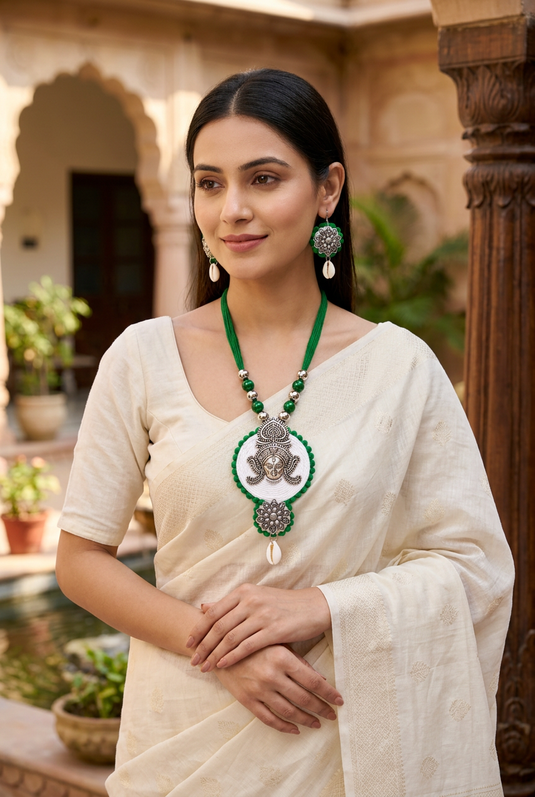 Indian woman wearing GARIMAS green necklace and matching earrings