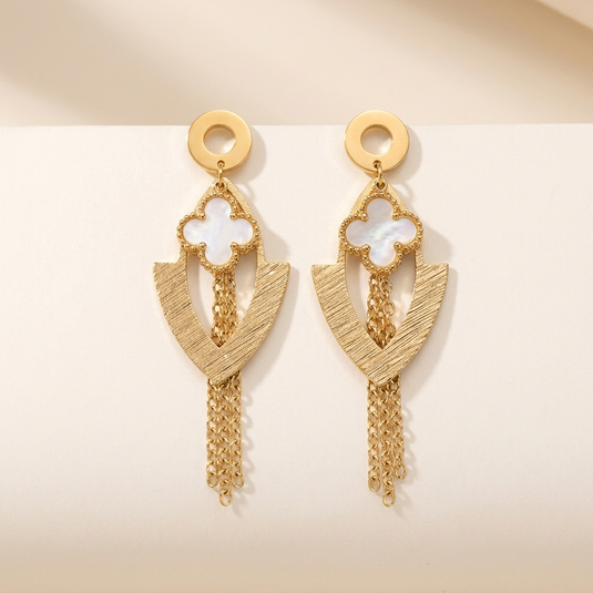 Pair of gold-tone quatrefoil earrings with textured V-shaped drops and chain tassels on a white background