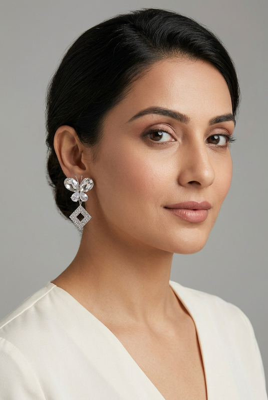 GARIMAS silver-tone butterfly drop earrings with sparkling square rhinestone pendants, worn by a model.