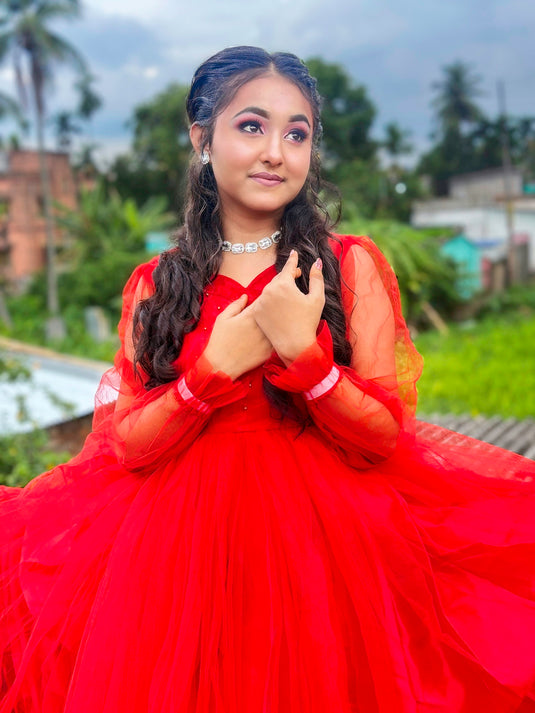 A woman poses in a red dress.
