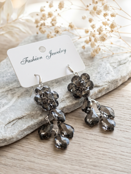 GARIMAS pair of smoky grey floral drop earrings with faceted teardrop accents and silver-tone hooks.