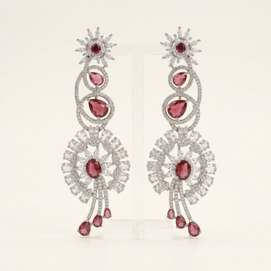 GARIMAS pink floral drop earrings with clear stone detailing and silver-tone loops on a white studio background.