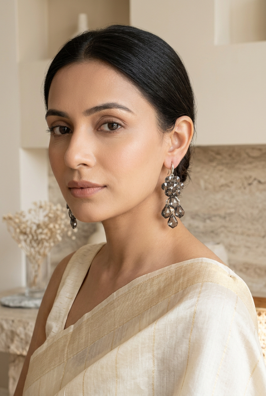 GARIMAS smoky grey floral drop earrings worn with an ivory saree.