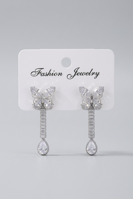 GARIMAS silver butterfly drop earrings with clear rhinestones, displayed on a white card against a light grey background.
